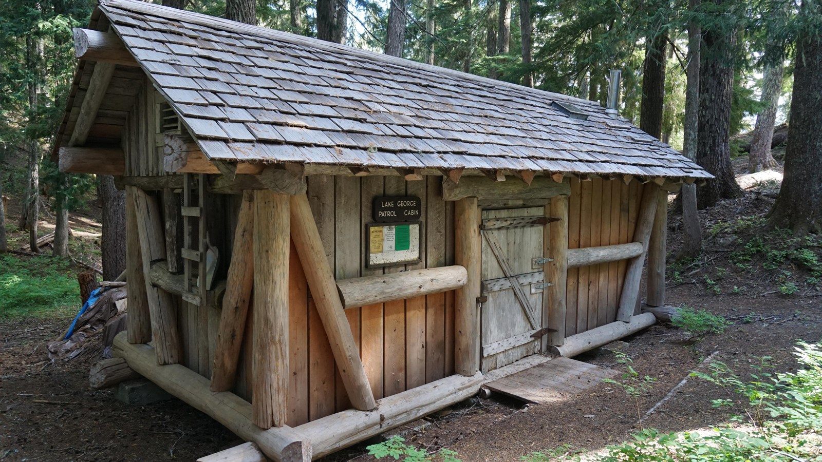 Wood-frame, one-story, two-room, rectangular cabin with a medium-pitched cedar shake gable roof 