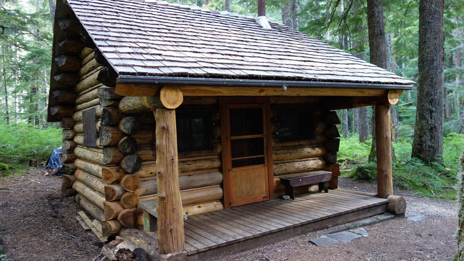 Small log cabin surrounded by forest that measures 14\' x 19\' with a floor size of 279 square feet