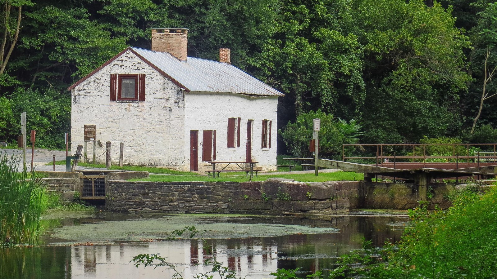 A white lockhouse sits on the far sid of a watered canal.