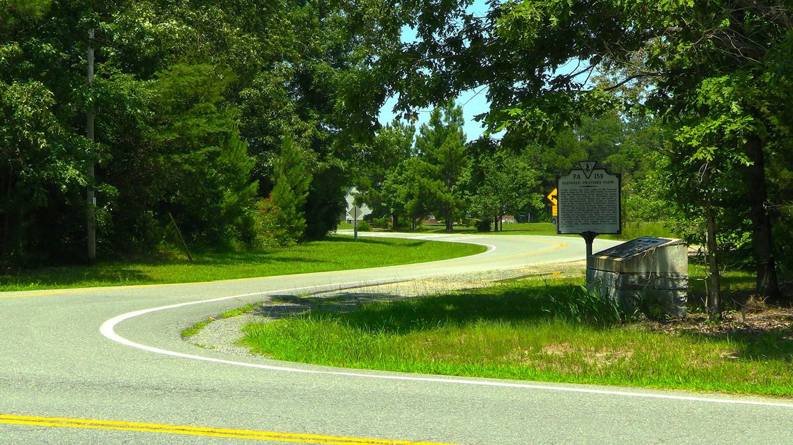 A two lane road forms a gentle 
