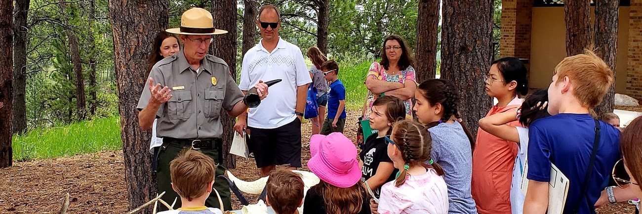 Ranger with antlers in front of crowd.