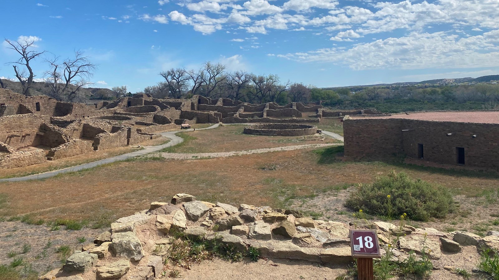 An overlook of the northeast corner a sandstone great house under a blue sky.