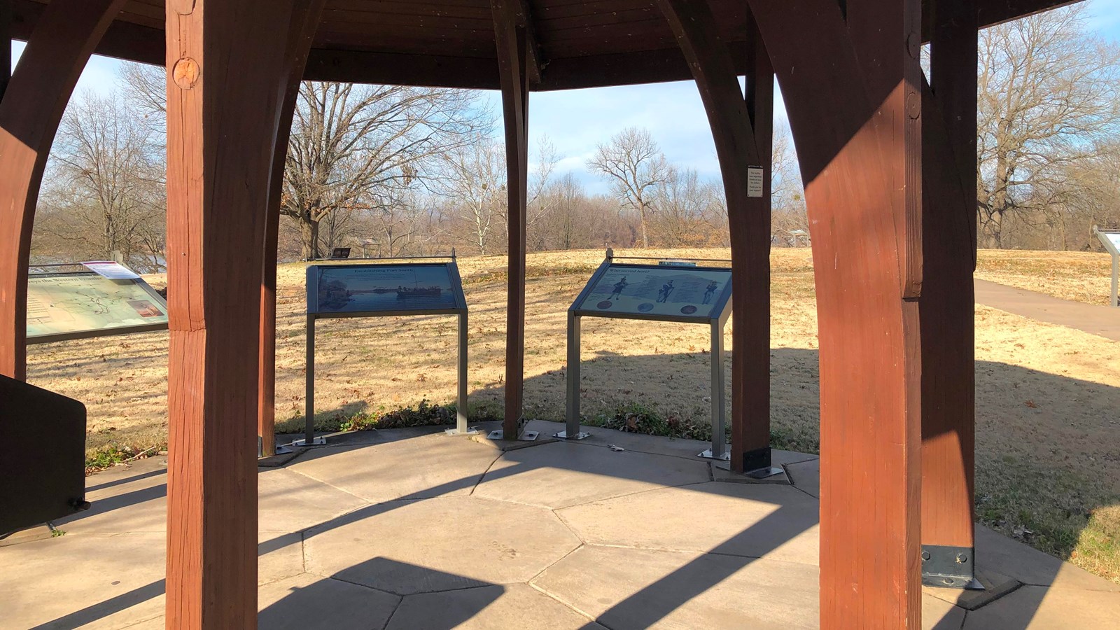 Two waysides in the shadow of a gazebo.