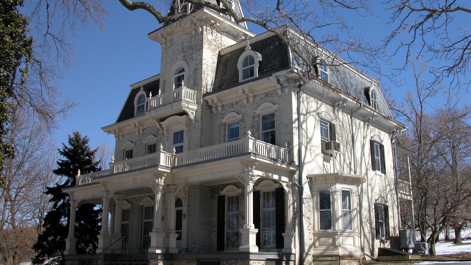 A large, three-story, second empire style house.