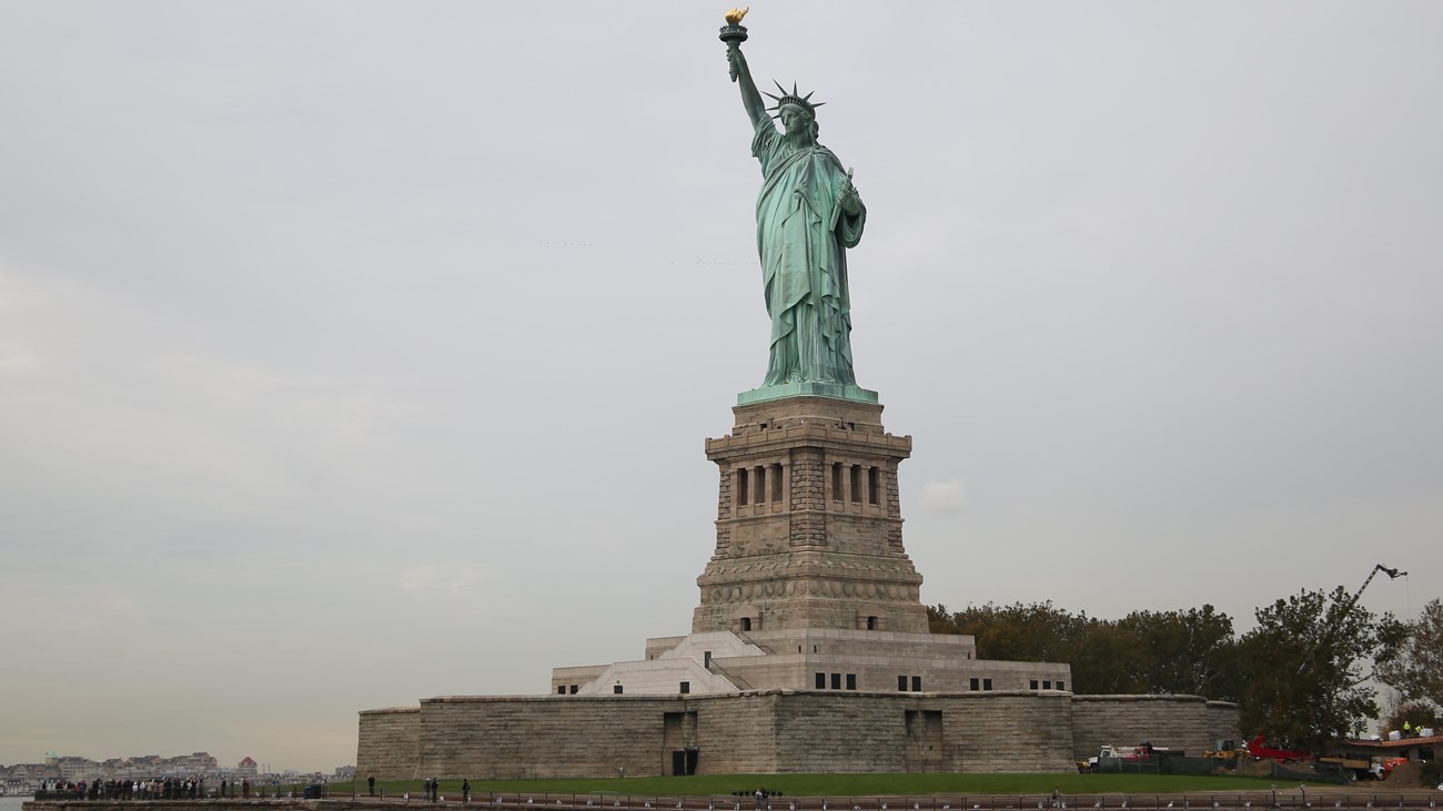 A view of the Statue of Liberty and Liberty Island from the water.