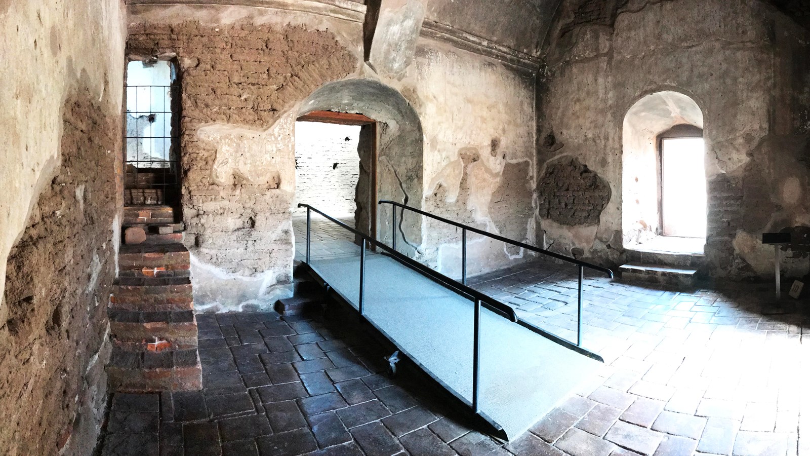sacristy room with stairs to pulpit on left, entrance to sanctuary with ramp, window to the right