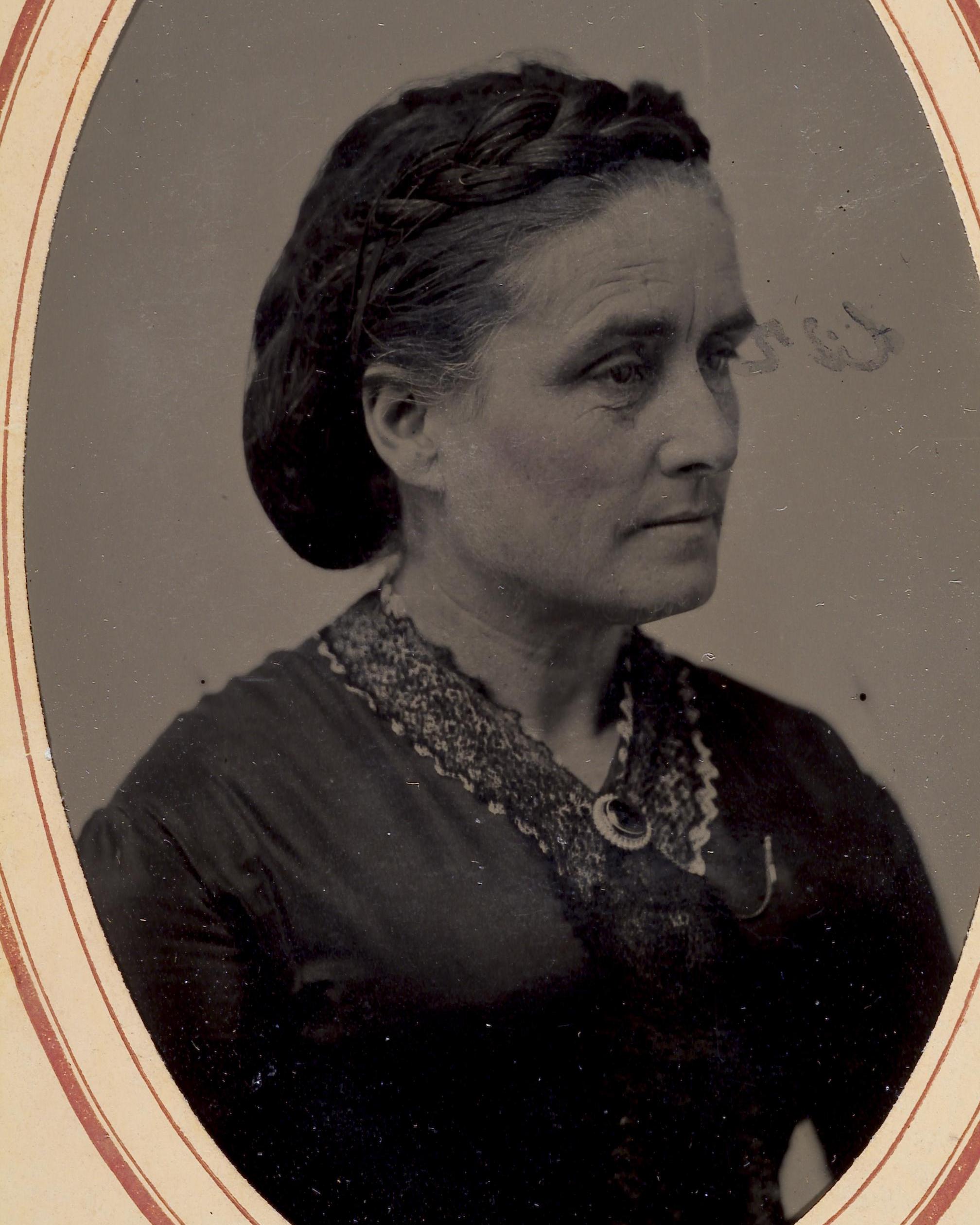 A historic photo of a woman in fancy dress and a broach