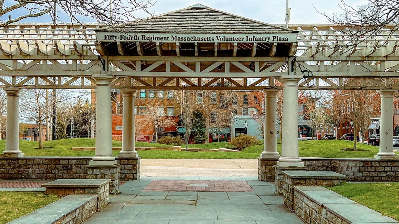 A wide walkway leads to a sign reading 