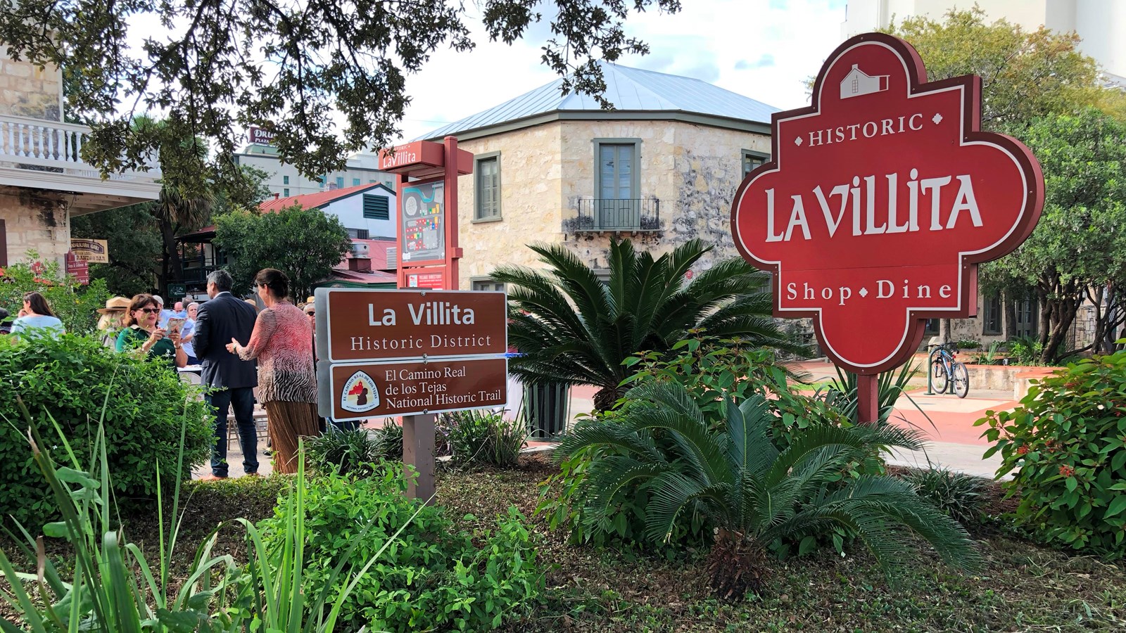 A large brown sign in front of a downtown historic area.