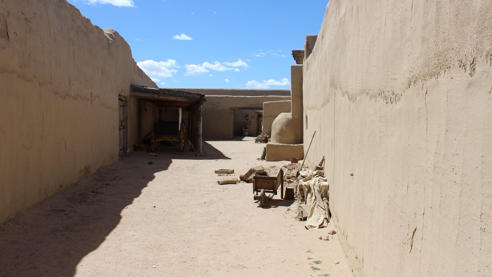 A narrow triangular area defined by tall adobe walls. 