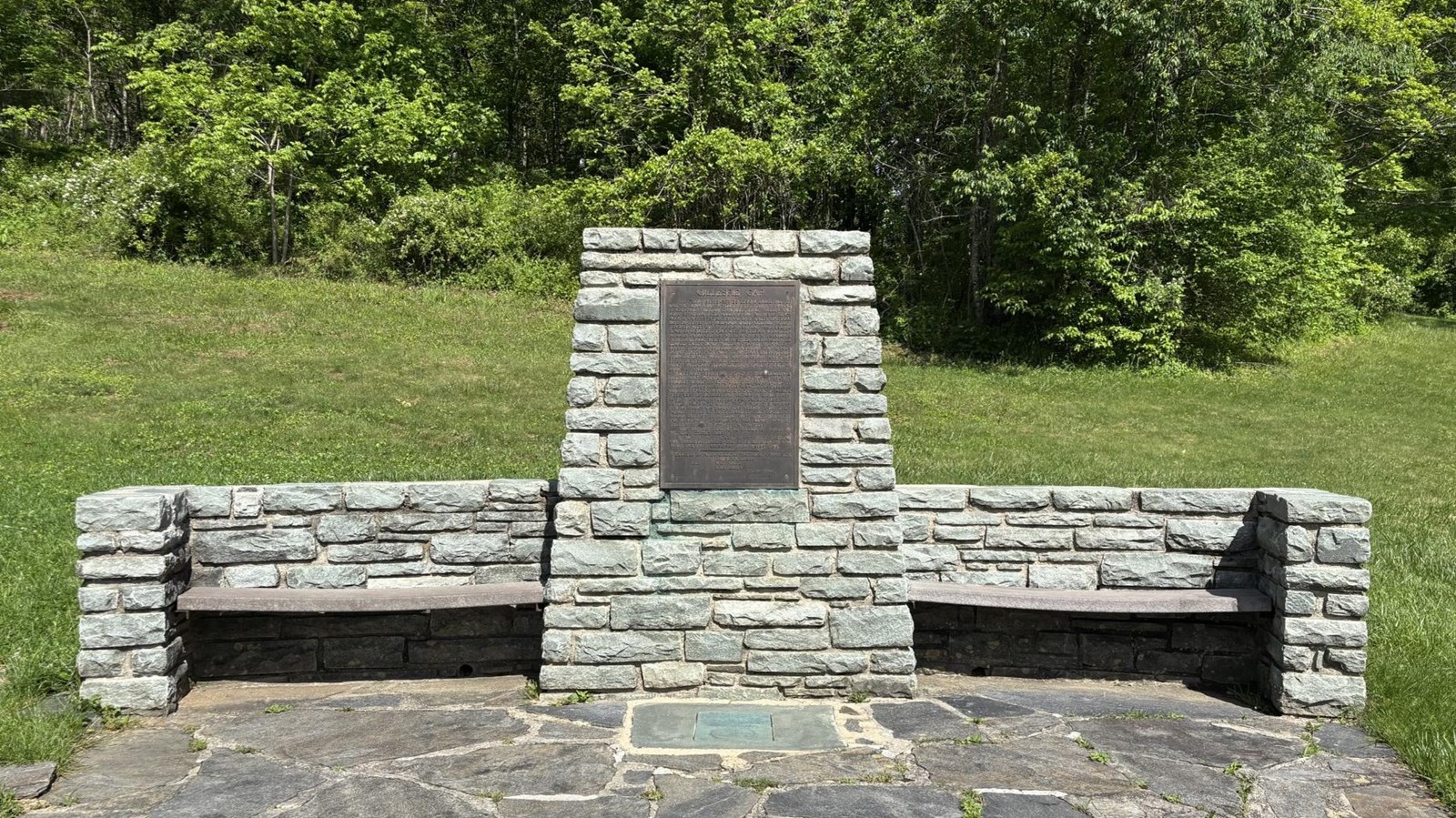 Monument made of local stones shaped with a center pillar 6 ft or so high and benches on each side.