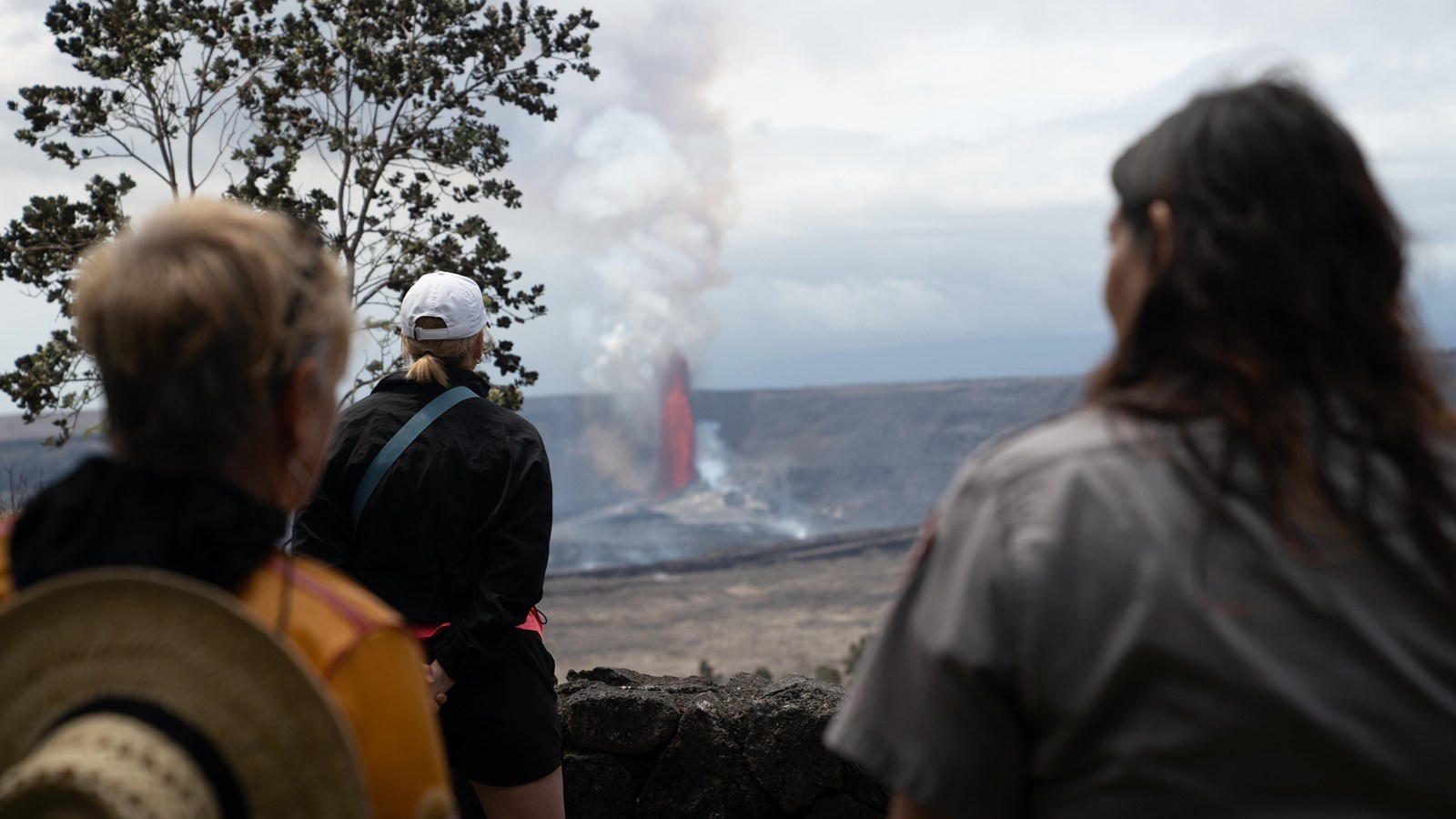 Visitors look into an erupting crater.