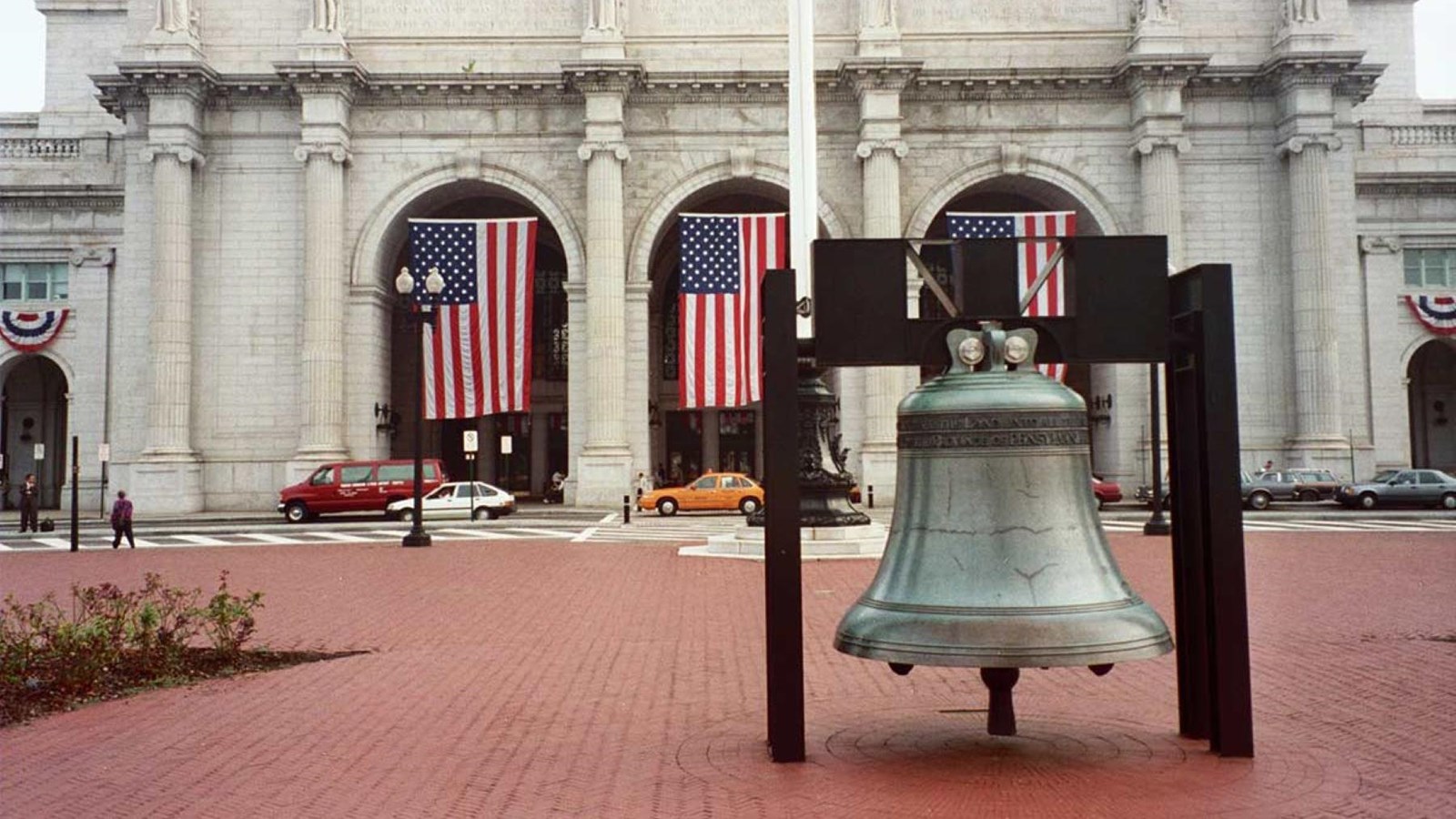 Large bronze bell in front of a white marble fountain