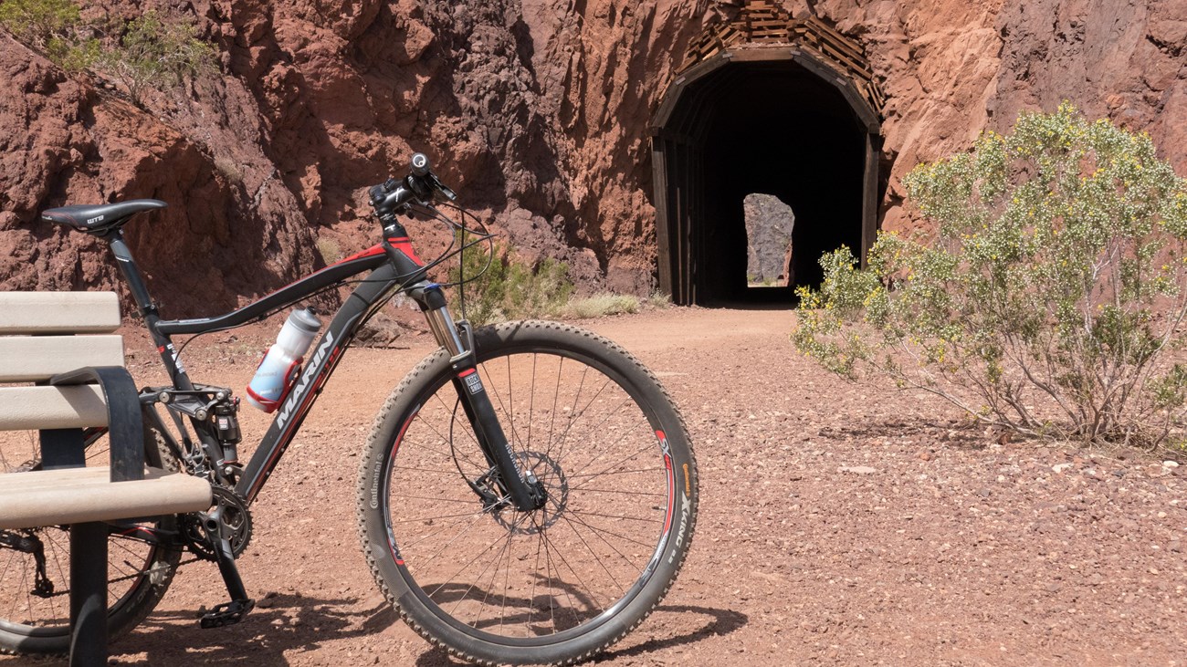 A bike sits on a path overlooking a lake