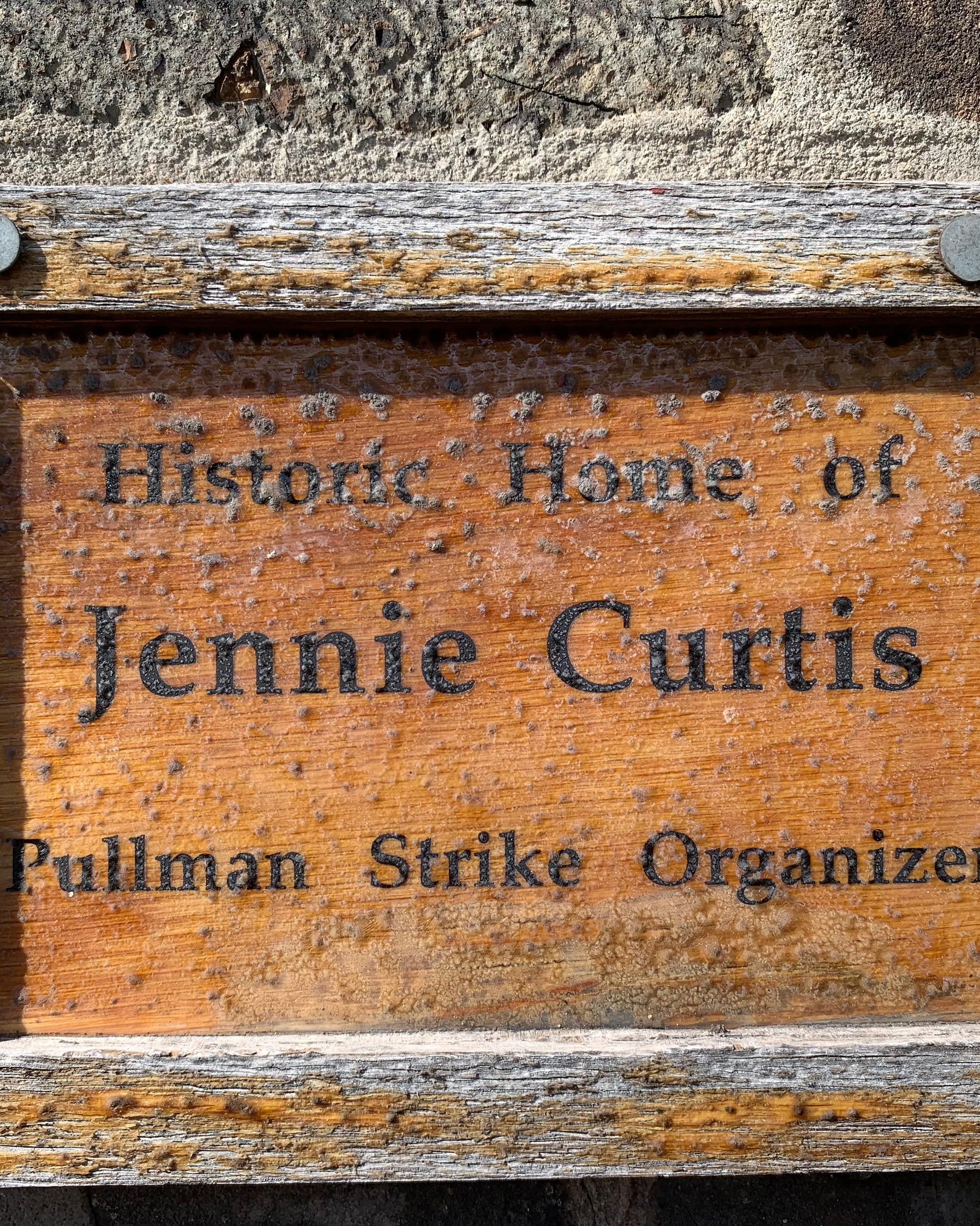 A wooden plaque that says "Historic Home of Jennie Curtis Pullman Strike Organizer".