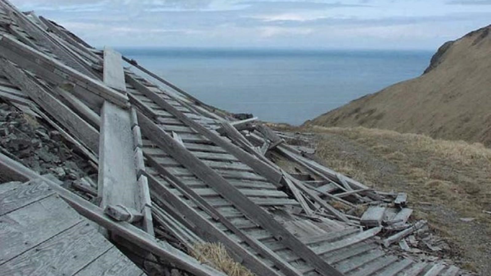 collapsed building with ocean backdrop. 