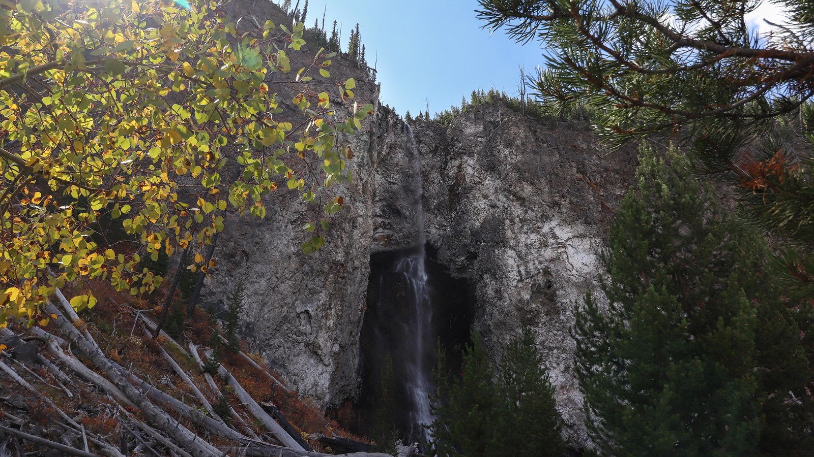 A thin waterfall cascades down a rocky cliff.
