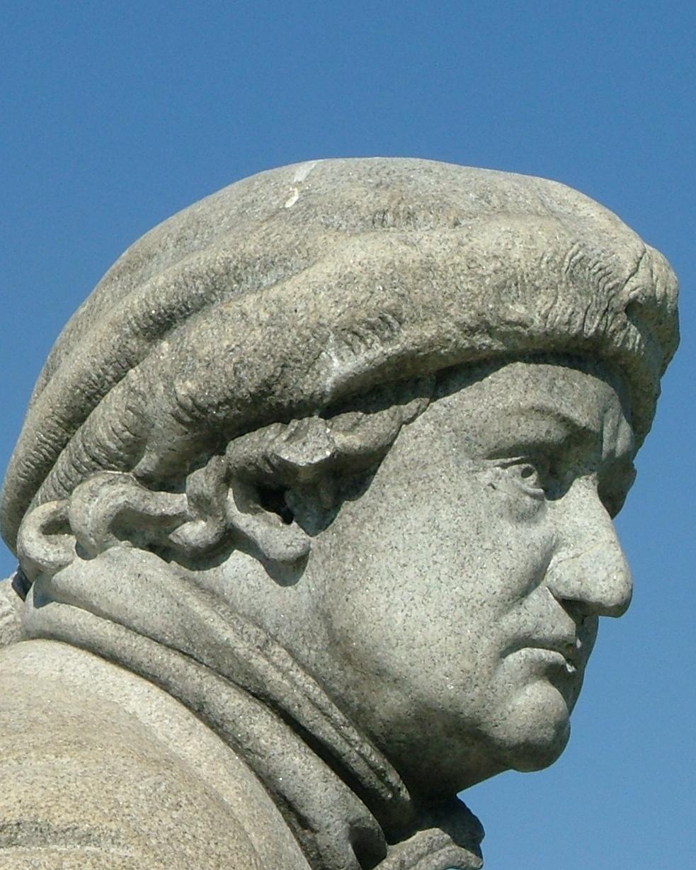 stone statue showing the head of a man outlined in blue sky