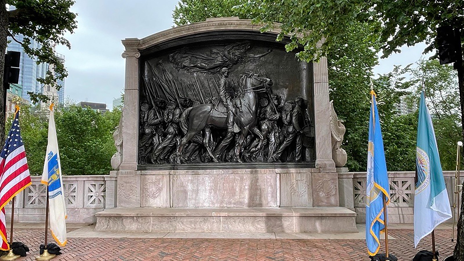 bronze relief of a soldier on horseback with other soldiers marching