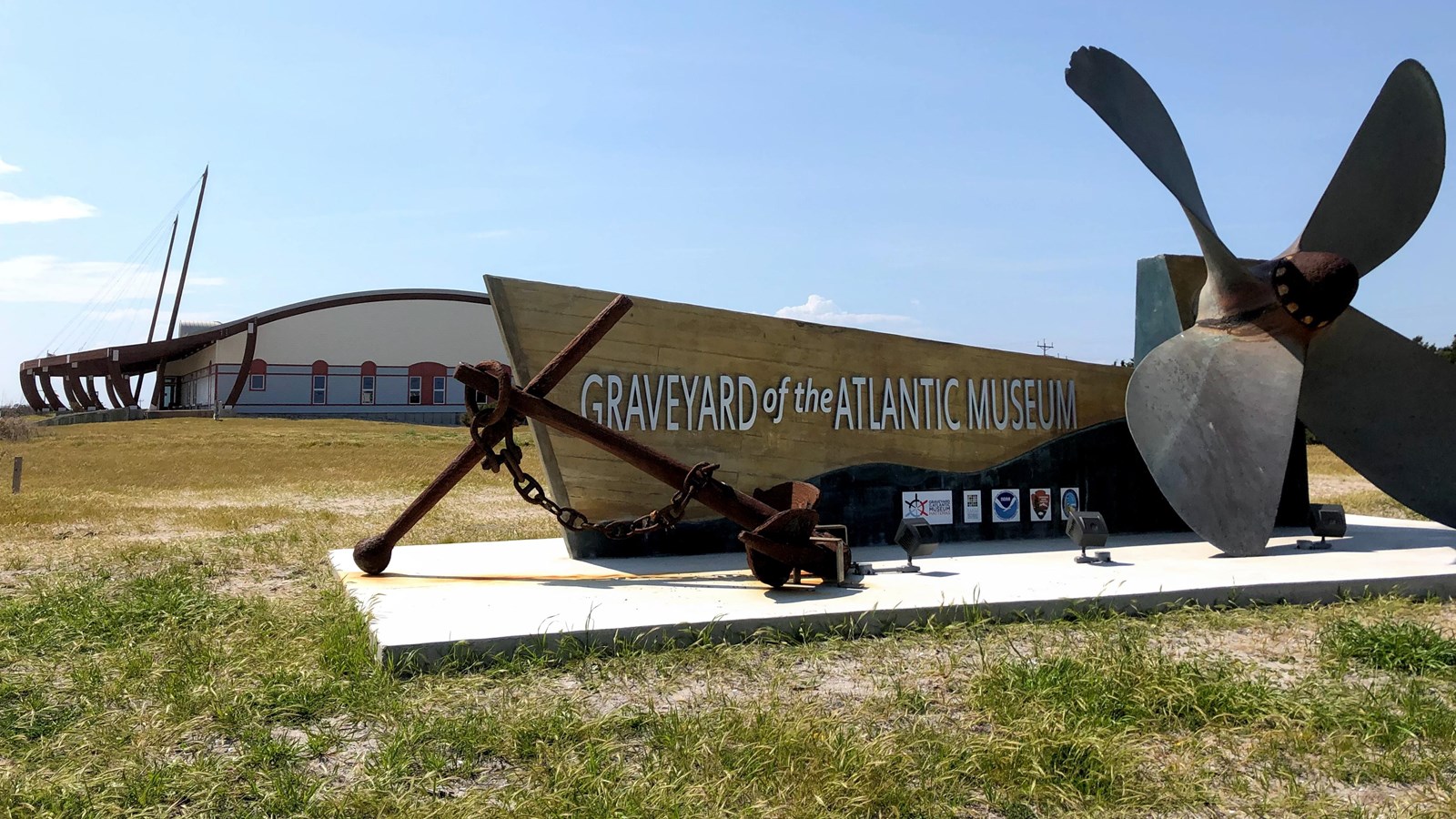 Anchor and wooden sign with a building in the background