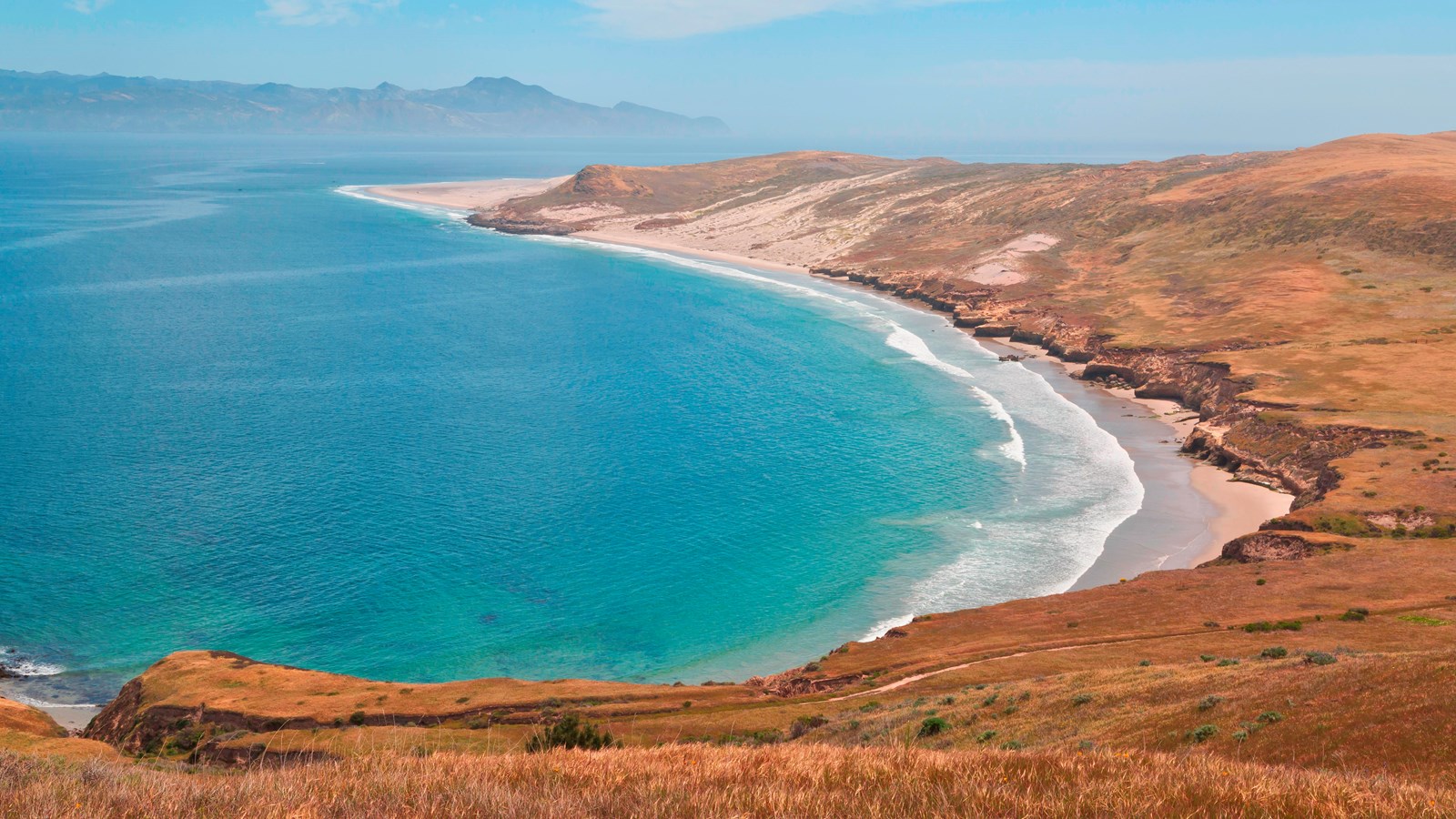 Crescent bay leading to a sandy point. 