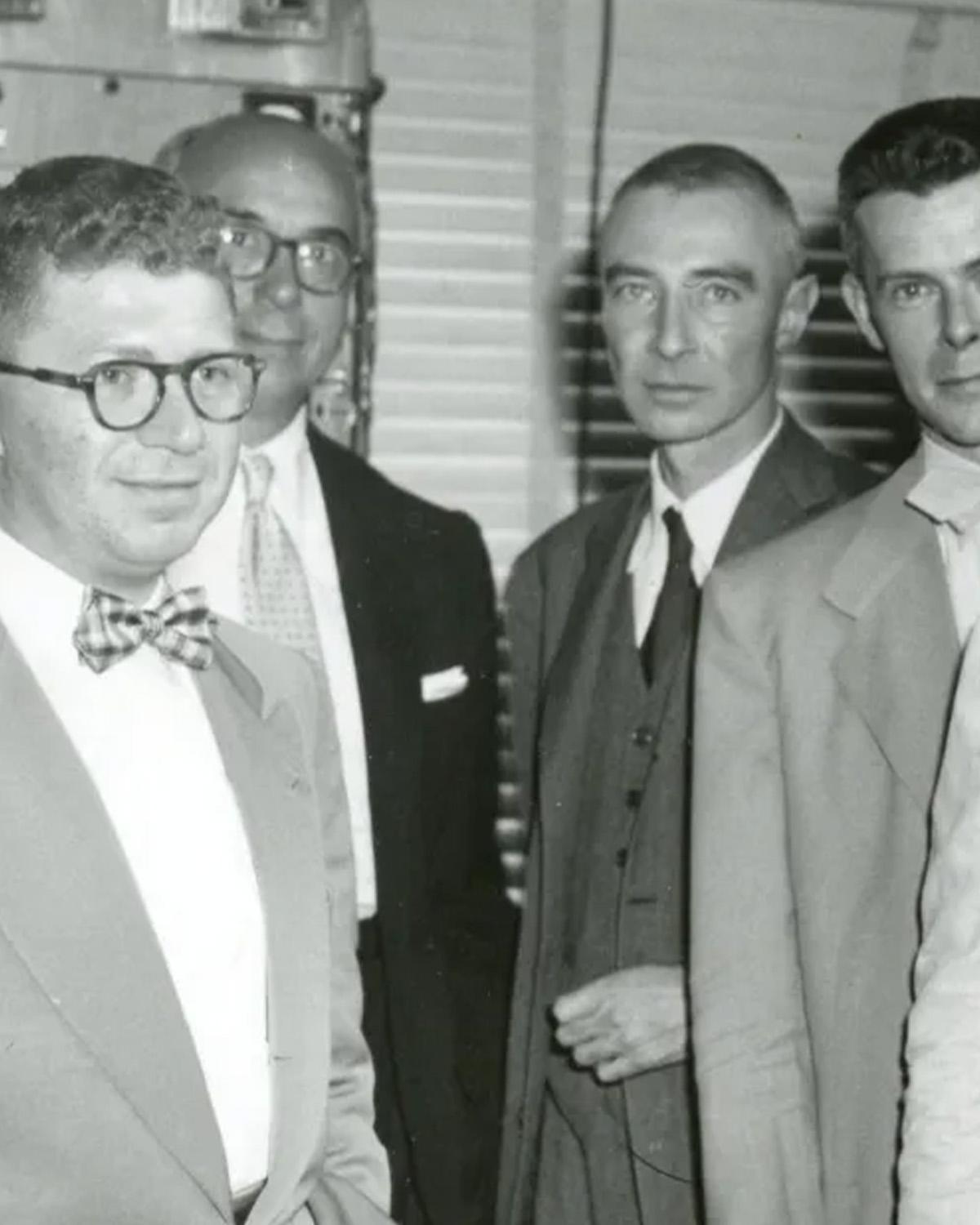 Black and white photo of four men standing in suits.