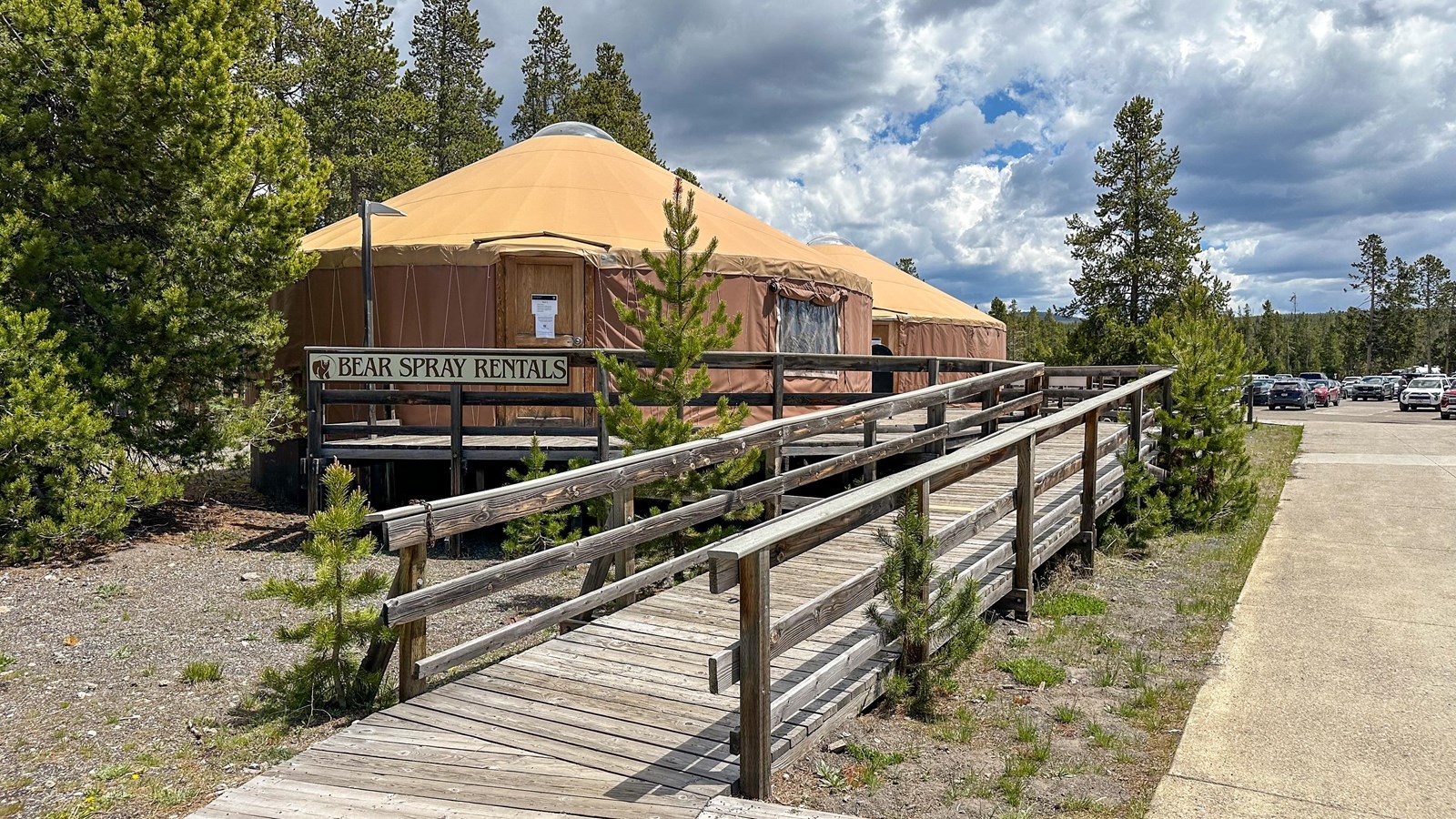 A large brown yurt with the sign that reads Bear Spray Rentals