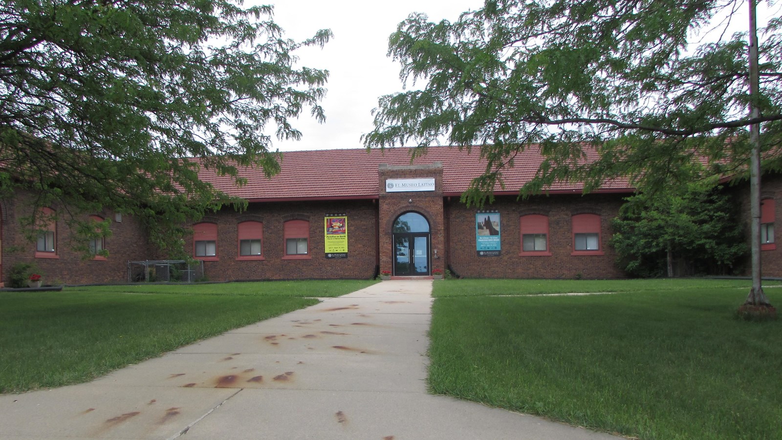 One-story, U-shaped building with grass courtyard. Central sidewalk leading to front entry.