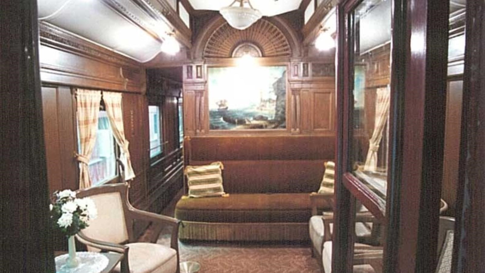 A lavish interior of a train car with hand crafted wooden furniture.