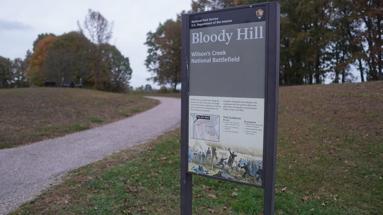 Bloody Hill Hiking Trail with wayside sign giving information about Bloody Hill.