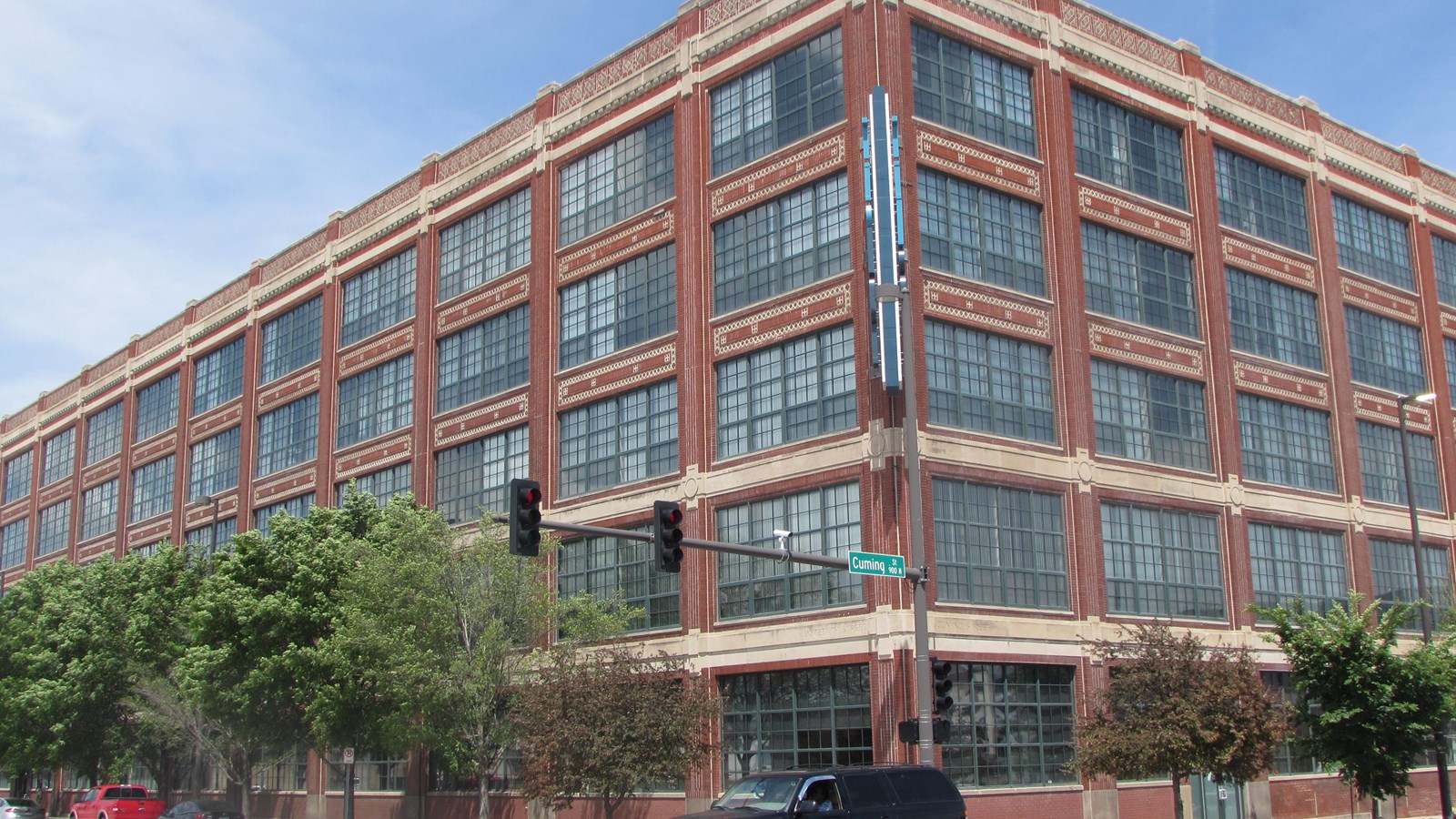 Angled view of four story brick assembly plant with large windows across each level