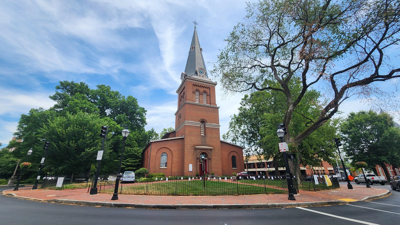 A brick church building in a circle with trees around it.