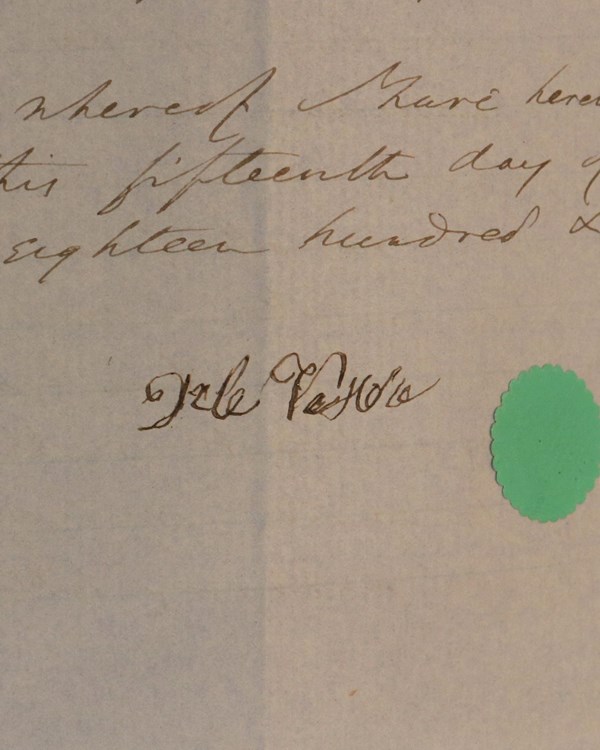 Handwritten document with a signature and green seal