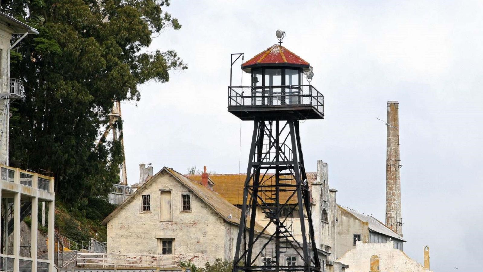 The Alcatraz guard tower with black metal struts and a red roof. 