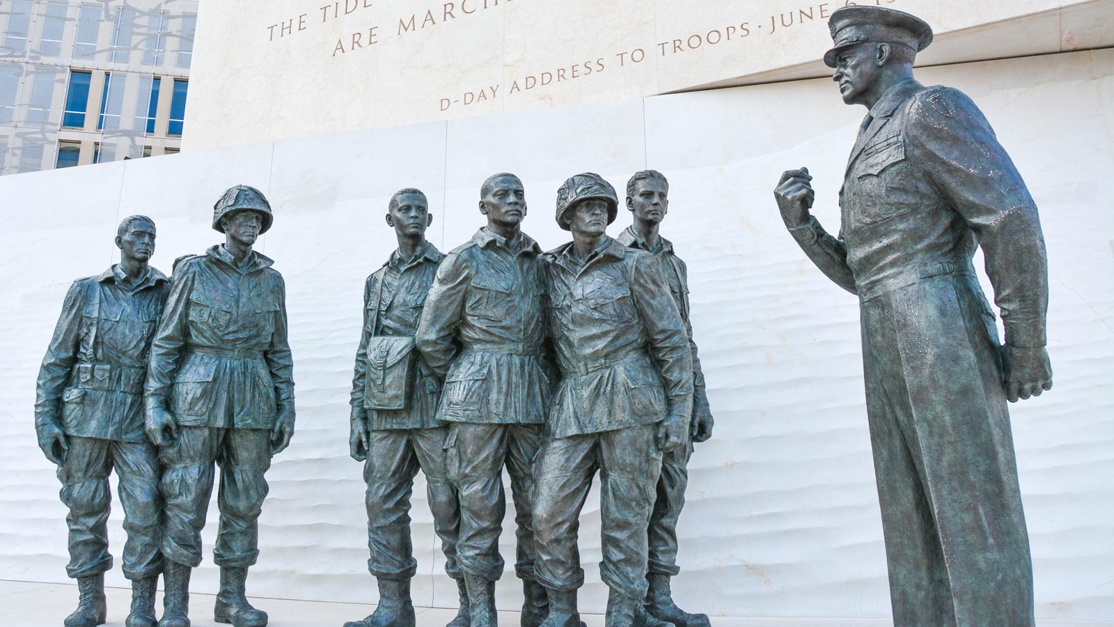 7 bronze statues grouped together. The main statue depicts a man speaking to a group of soldiers.