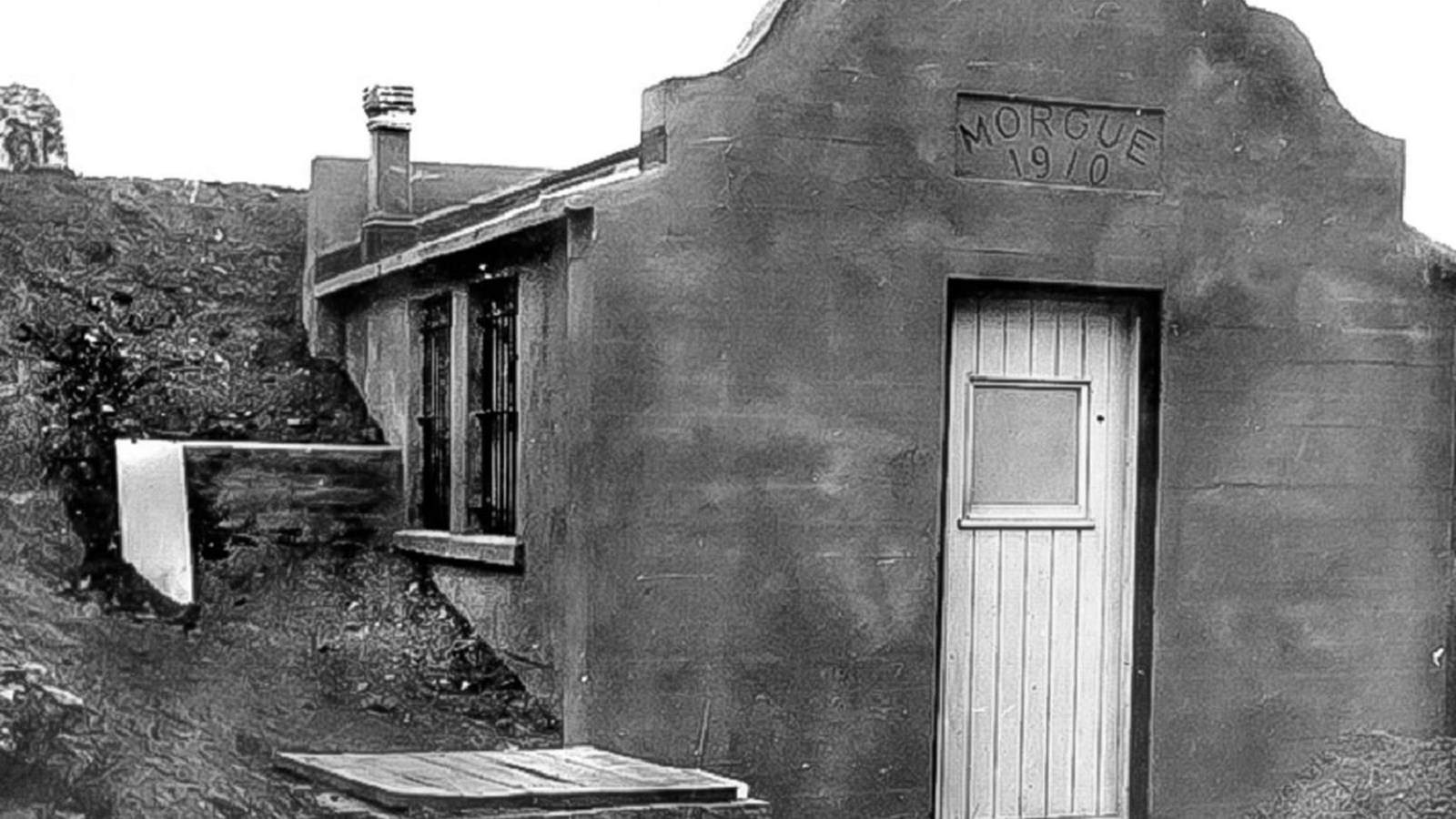 A white, wooden door is the entrance to the Mission Revival style Alcatraz morgue.