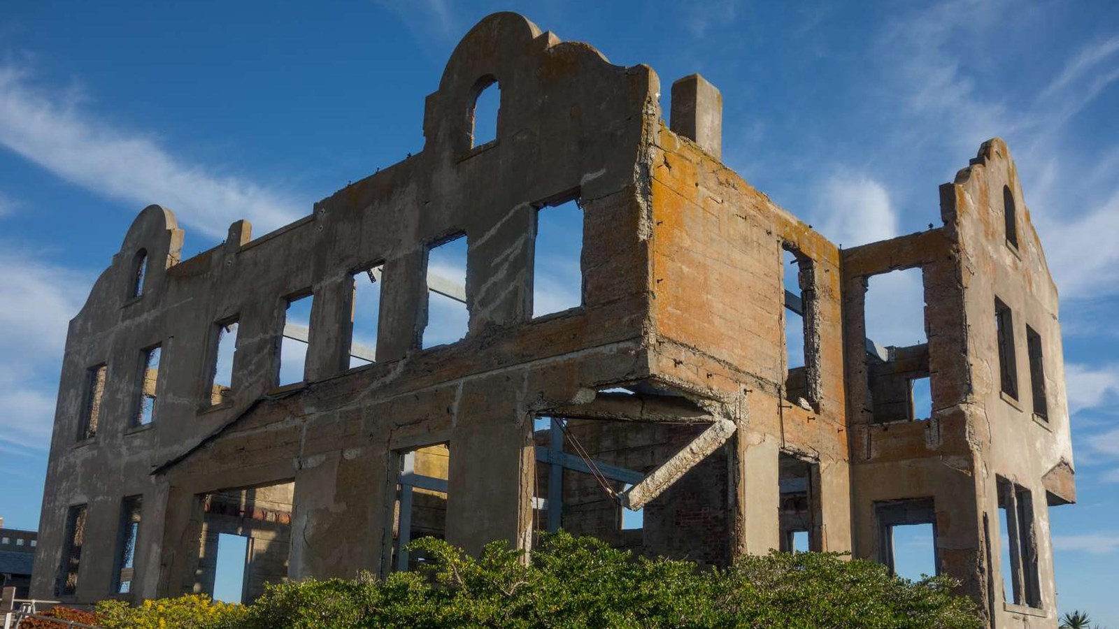 The outer concrete shell of the original three story structure with many windows. 