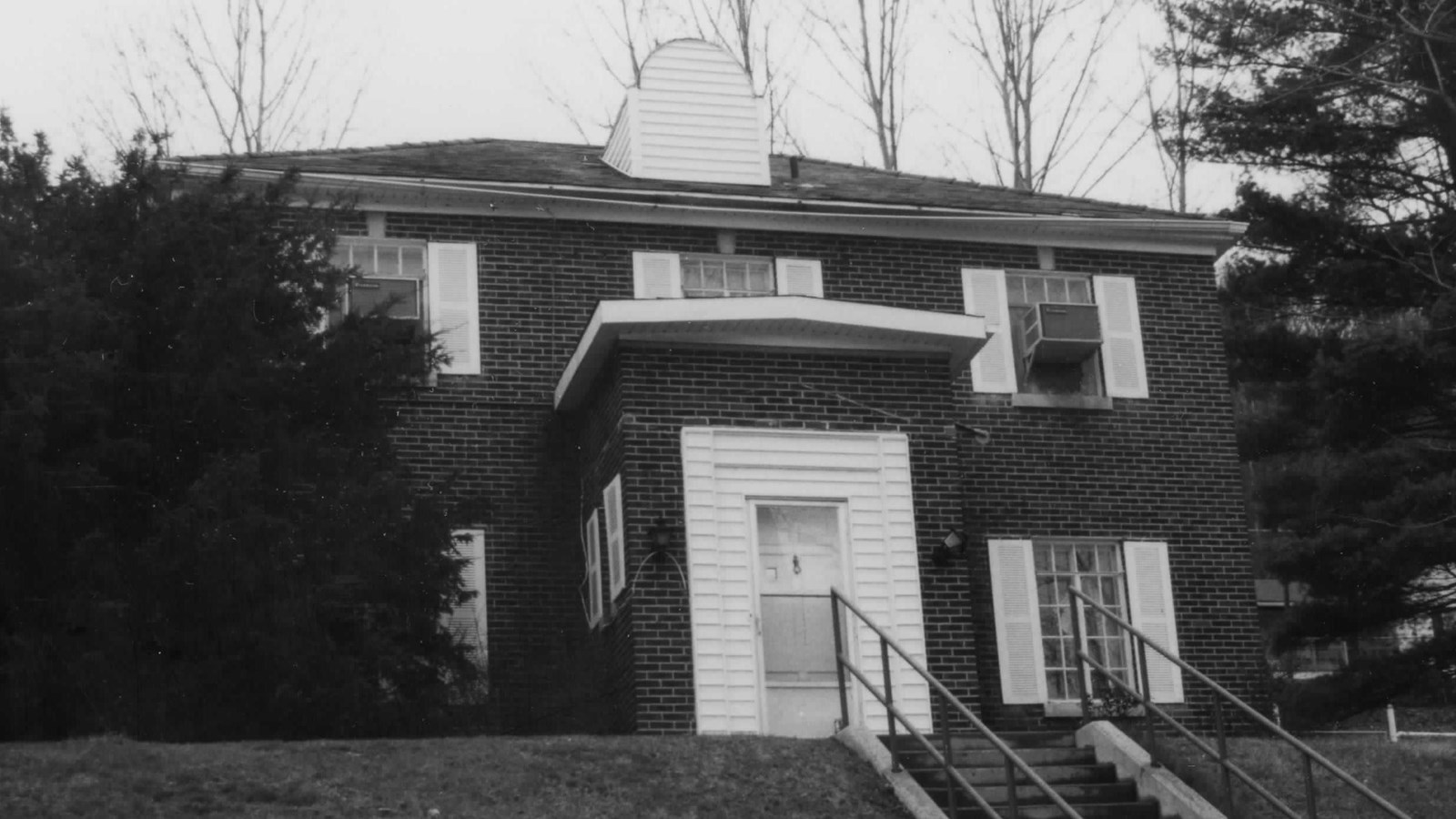 Brick house on a hilltop with white accents