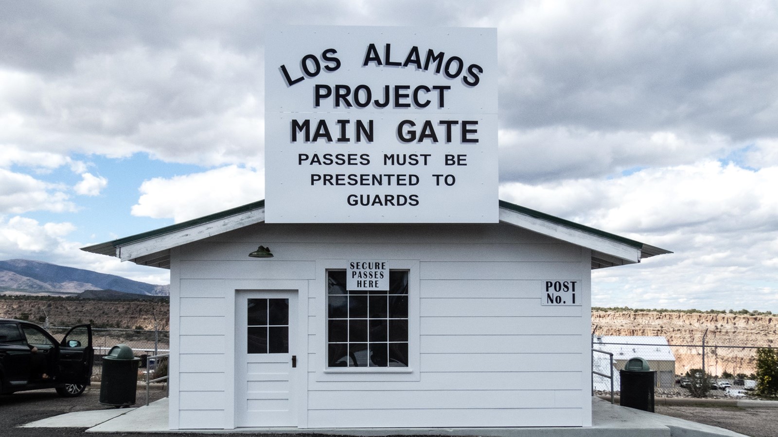 A small white sided building with a sign reading 