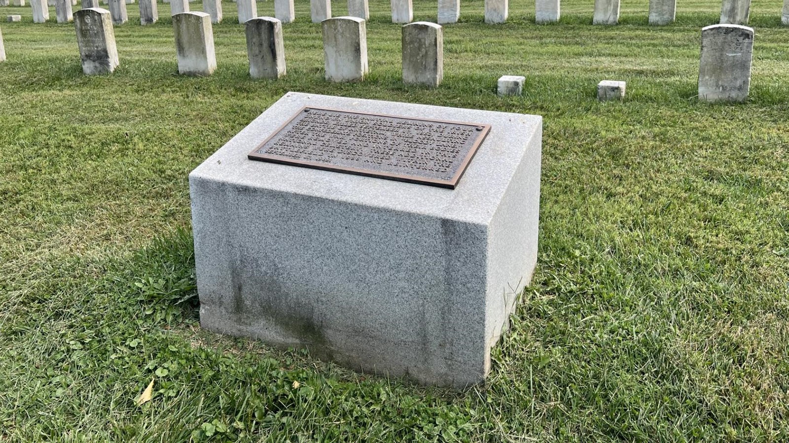 short granite marker with bronze plaque mounted on the top