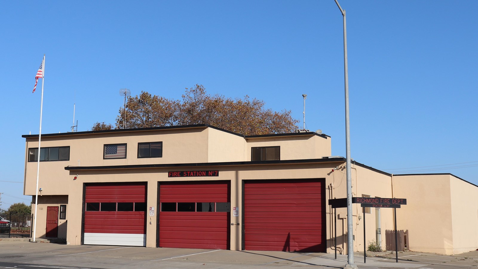 One story historic fire station with two garage doors and a sign. 