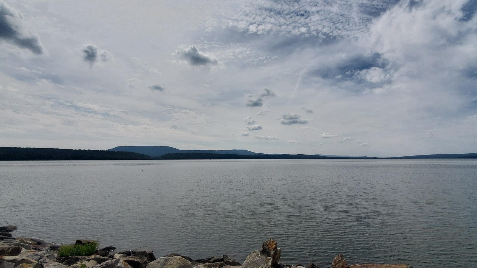 Expansive flat lake with the bluffs of the Ouachita Mountains on the far side. 