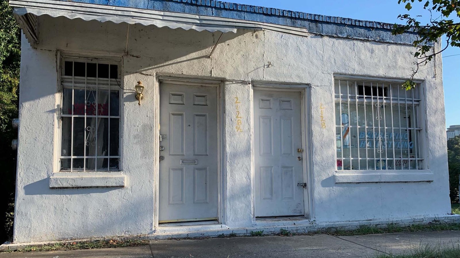 Rectangular, white, small, single story, concrete block commercial building with a brick veneer