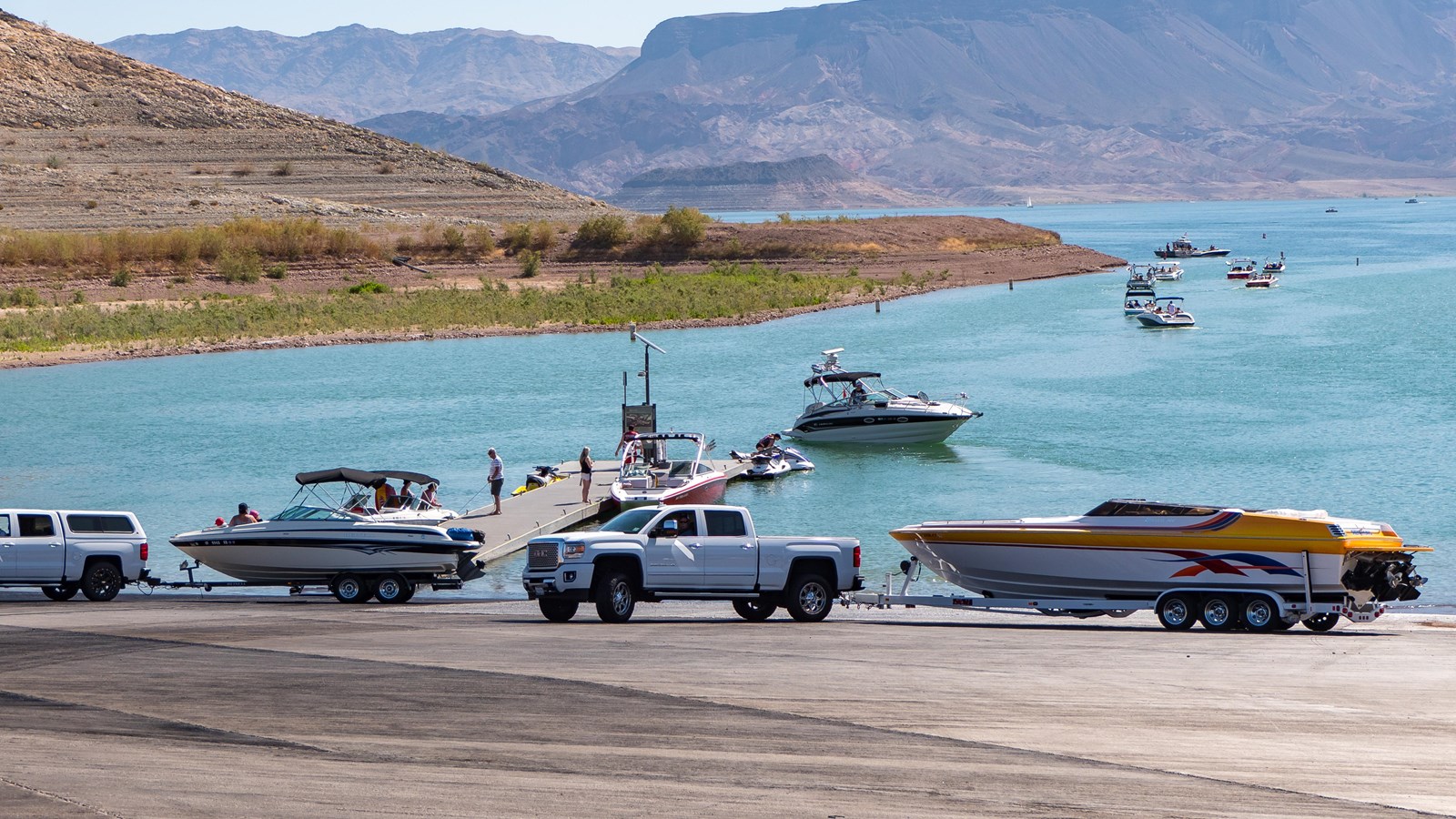 Launch ramp into the lake with several trucks and boats.