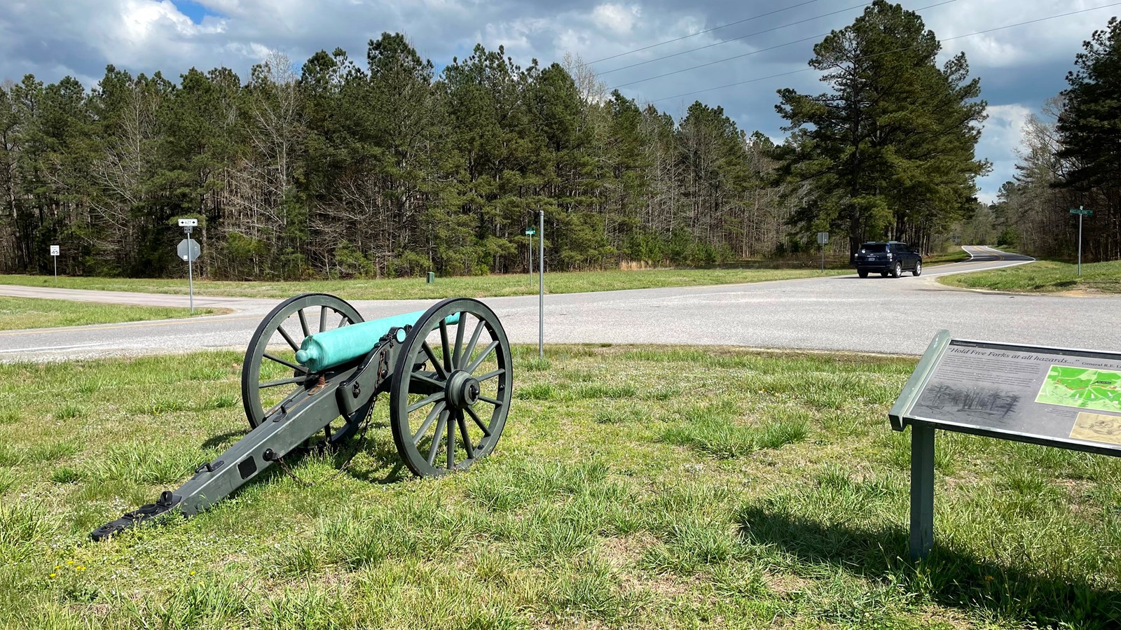 Wayside and cannon in the foreground and a 5 road intersection in the background,