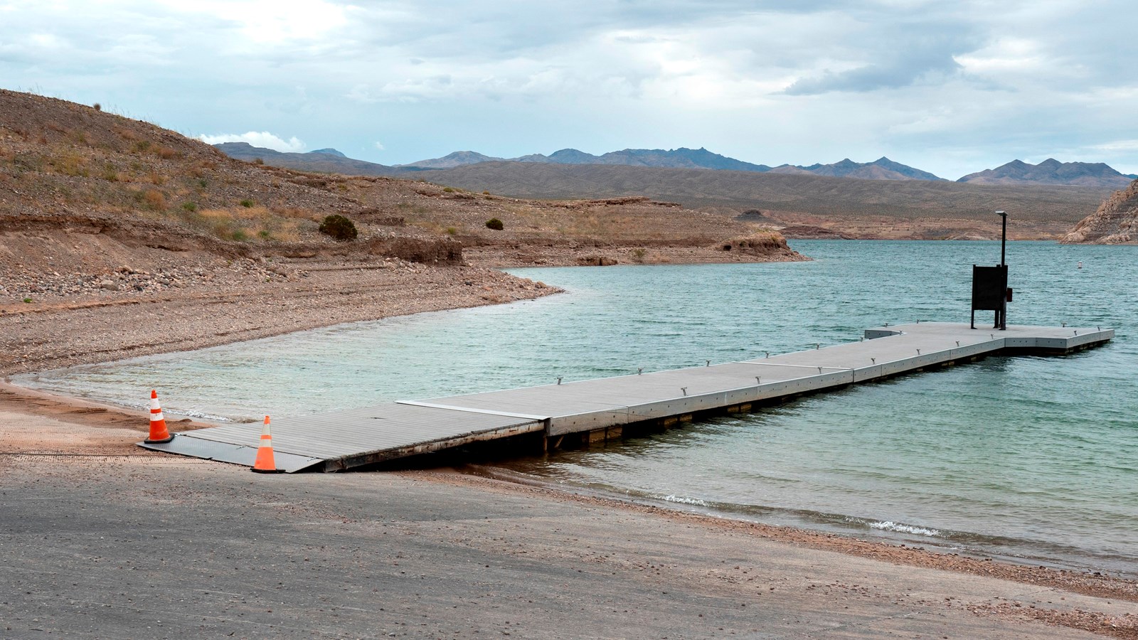 Launch ramp into the lake with several trucks and boats.