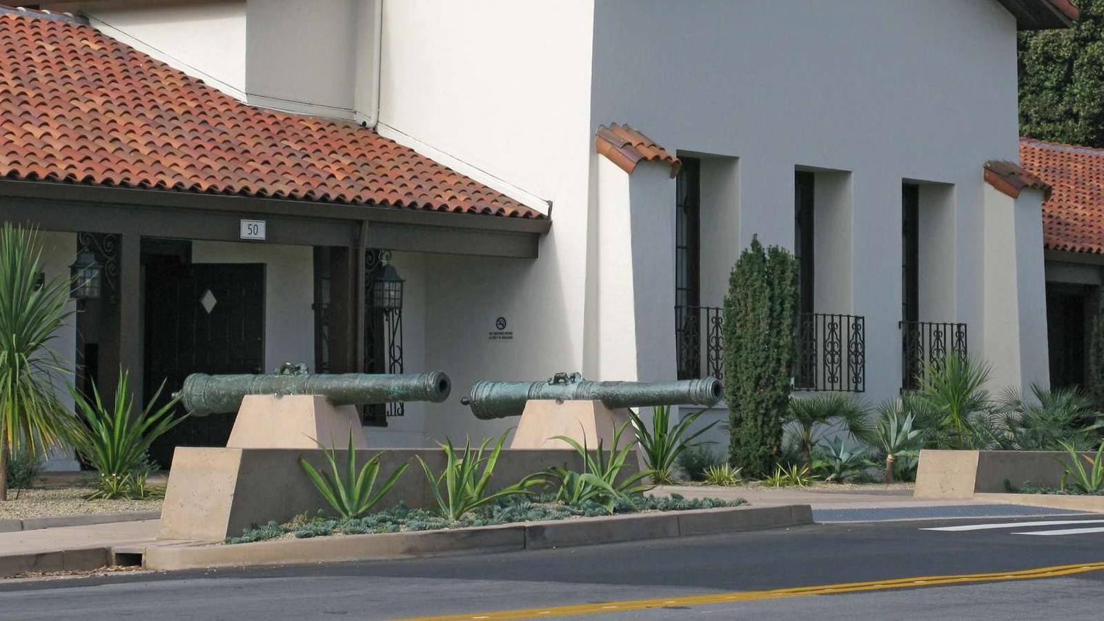 View of entrance to the Officers\' Club with two bronze cannons.