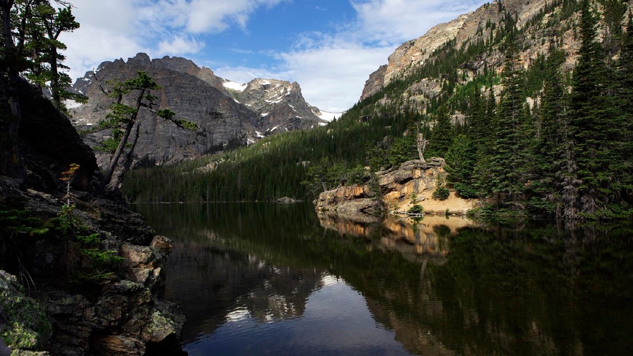 a mountain top is reflected in a lake