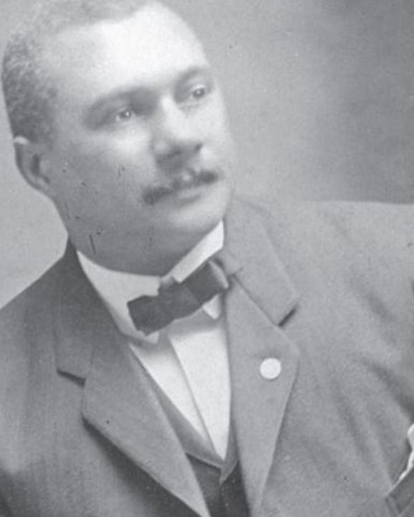 A photo of an African American man, Harry, leaning to the left, with a bowtie. Formal photo.