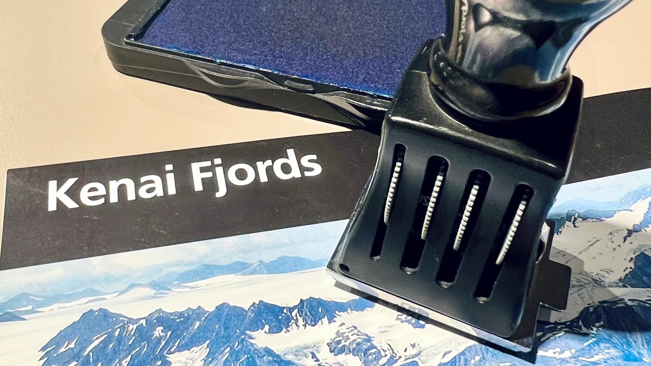 A park cancellation stamp on top of Kenai Fjords brochure